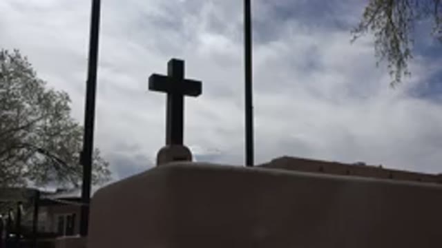 TAOS NEW MEXICO-2015: A Church Cross On A Street Corner On A Shady Day Near An Oak Tree