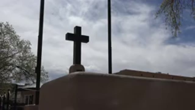 TAOS NEW MEXICO-2015: Cross On Top Of Church Building With Blue Sky Clouds And Trees