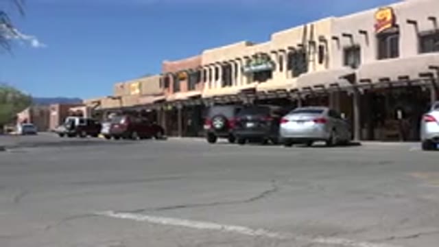 TAOS NEW MEXICO-2015: Dogs Parked In Front Of Buildings Crossing Road