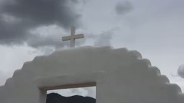 TAOS NEW MEXICO-2015: White Cross Atop White Stone Structure Arch Clouds In Sky