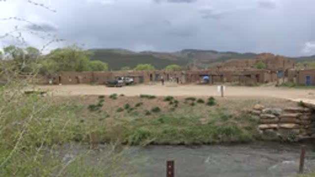 TAOS NEW MEXICO-2015: Buildings Next To A Rapid Stream With Many Mountains In