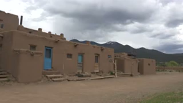 TAOS NEW MEXICO-2015: Houses In The Desert On A Cloudy Day With Mountains