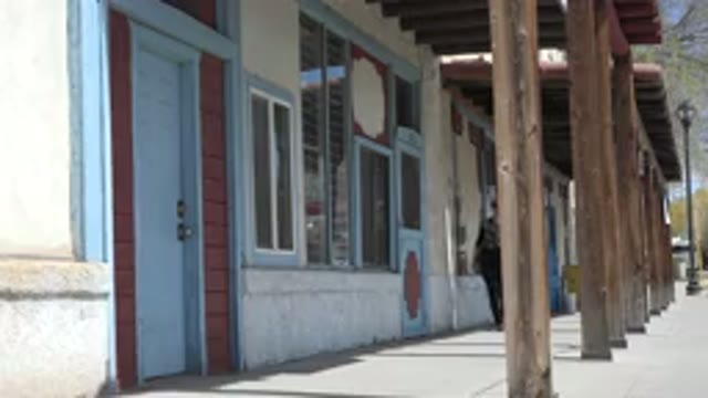 TAOS NEW MEXICO-2015: Woman In Jeans Black Blouse And Glasses Walking On The Sidewalk