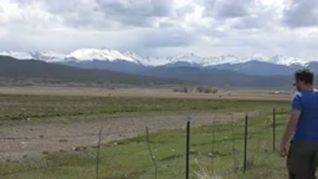 TAOS NEW MEXICO-2015: Man Wearing Blue Shirt Stands Near Wire Fence With Woman