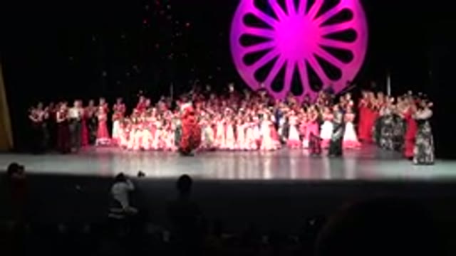 CABO SAN LUCAS MEXICO-2019: A Woman In A Green And Red Dress With A Crowd Of