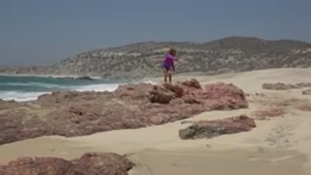 CABO SAN LUCAS MEXICO-2019: Child Playing On The Rocks On The Beach During A
