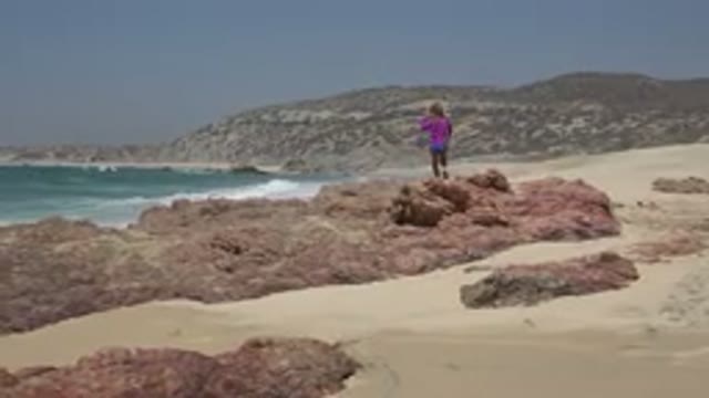 CABO SAN LUCAS MEXICO-2019: A Child Walking On Rocks At The Beach