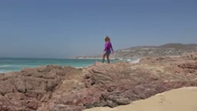 CABO SAN LUCAS MEXICO-2019: Little Girl Walking Around The Rocks On Beach