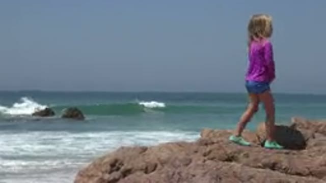 CABO SAN LUCAS MEXICO-2019: Child Walking On A Rock Near The Sea On A Sunny Day