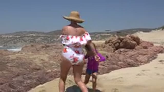 CABO SAN LUCAS MEXICO-2019: Mother And Daughter Play Ring-Around-The Rosie On Beach