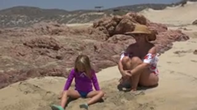 CABO SAN LUCAS MEXICO-2019: Woman And Kid Sitting On Beach Sand Wearing Beachwear
