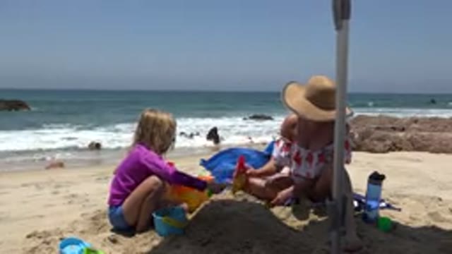 CABO SAN LUCAS MEXICO-2019: Mom And Daughter Sitting At The Beach Playing With