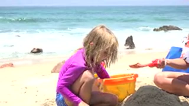 CABO SAN LUCAS MEXICO-2019: A Girl in Pink Dress Playing in Sand at Beach