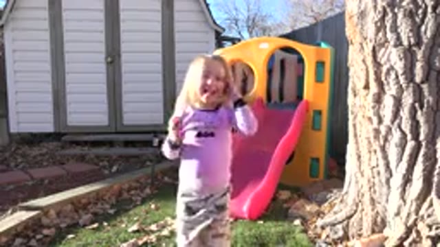 WESTMINSTER COLORADO-2019: Girl Wearing Pink Shirt Stands Near Red And Yellow Playhouse