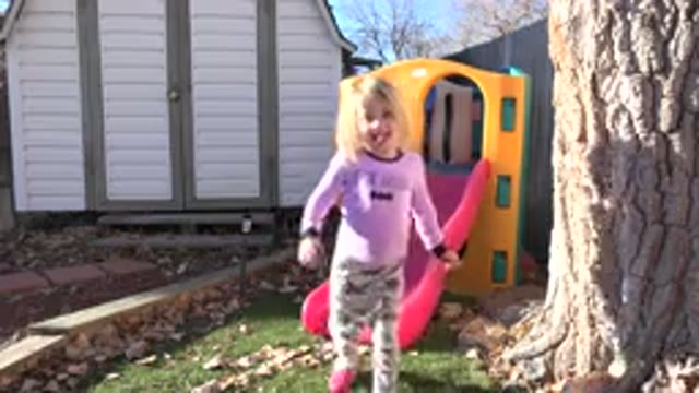 WESTMINSTER COLORADO-2019: Girl Wearing Pink Shirt Stands Near Red And Yellow Playhouse