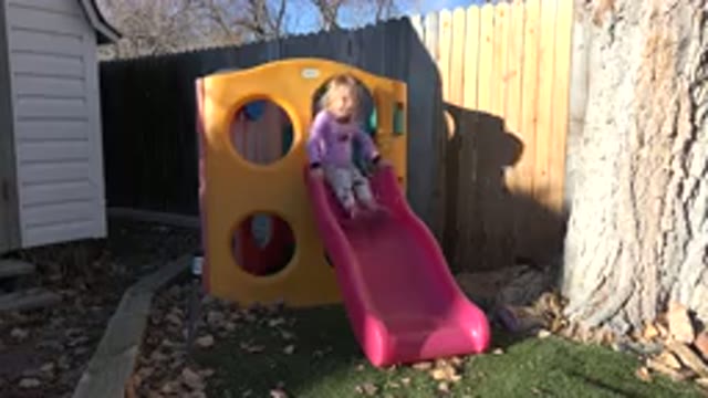 WESTMINSTER COLORADO-2019: Little Girl Enjoys Sliding Down Outdoor Playground Equipment
