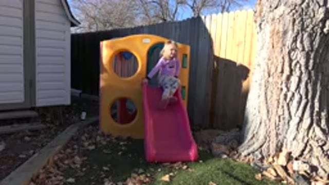 WESTMINSTER COLORADO-2019: A Child Sitting At The Top Of A Slide Then Sliding