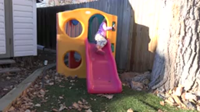 WESTMINSTER COLORADO-2019: A Little Girl On The Top Of The Slide On A Sunny Day