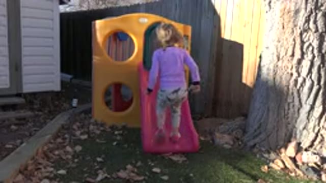 WESTMINSTER COLORADO-2019: A Little Girl With Blond Hair Playing On A Yellow Slide