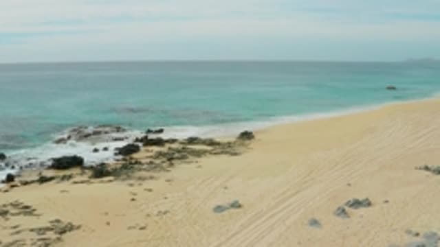 LAGUNA BEACH LOS CABOS BCS MEXICO-2021: Gentle Waves Lapping Sandy Beach with Rocky Outcrops