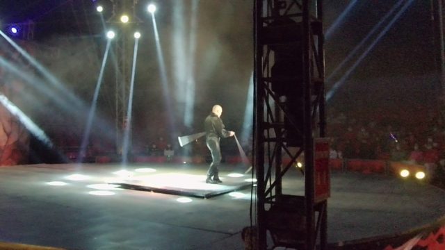 SAN JOSE DEL CABO BCS MEXICO-2022: Stage Performer Waving Flag Under Spotlights