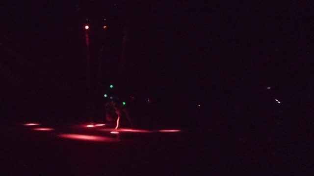 SAN JOSE DEL CABO BCS MEXICO-2022: A Performer with Green Lights Dances on a Dark Stage with Red Floor Lighting
