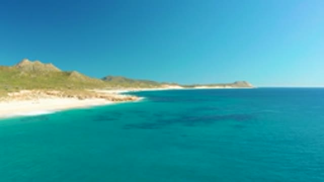BUZZARDS EAST CAPE LOS CABOS BCS MEXICO-2022: Calm Beach with Clear Blue Water and Distant Hills