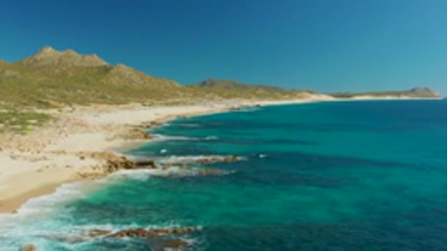 BUZZARDS EAST CAPE LOS CABOS BCS MEXICO-2022: Turquoise Ocean Waves Crashing on Rocky Beach Shore