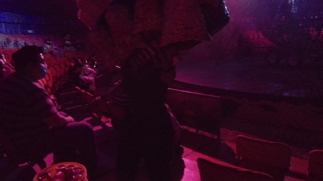 SAN JOSE DEL CABO BCS MEXICO-2022: People in a Dimly Lit Club with a Colorful Fabric Display