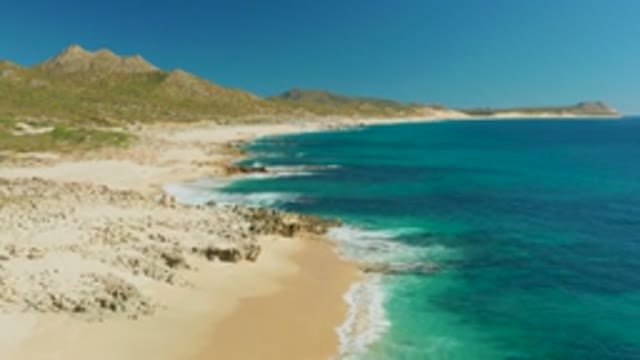 BUZZARDS EAST CAPE LOS CABOS BCS MEXICO-2022: Sandy Beach with Turquoise Ocean Waves and Rocky Shore