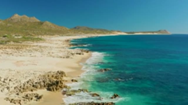 BUZZARDS EAST CAPE LOS CABOS BCS MEXICO-2022: Gentle Waves Lapping Rocky Beach Shore