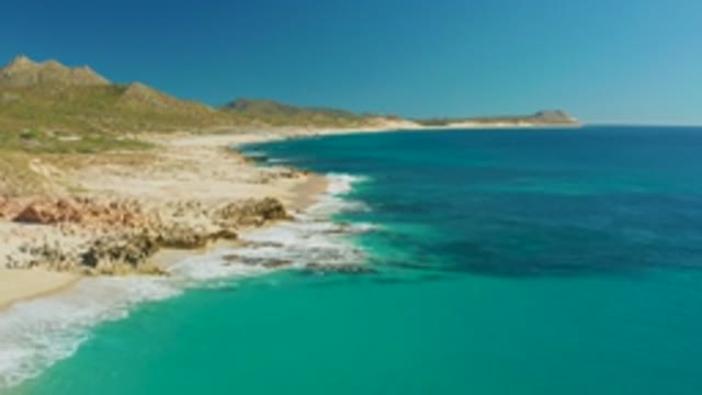 BUZZARDS EAST CAPE LOS CABOS BCS MEXICO-2022: Waves Crashing on Rocky Shoreline with Sandy Beach