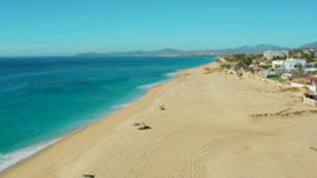 BUZZARDS EAST CAPE LOS CABOS BCS MEXICO-2022: People Moving on Sandy Beach by Ocean Waves