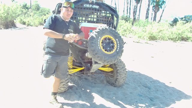LOS CABOS BCS MEXICO-2022: Man Drinking From Bottle Beside All-Terrain Vehicle