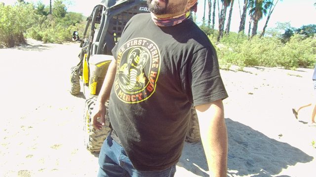 LOS CABOS BCS MEXICO-2022: Man in Black T-shirt Making Hand Gestures on Sandy Ground