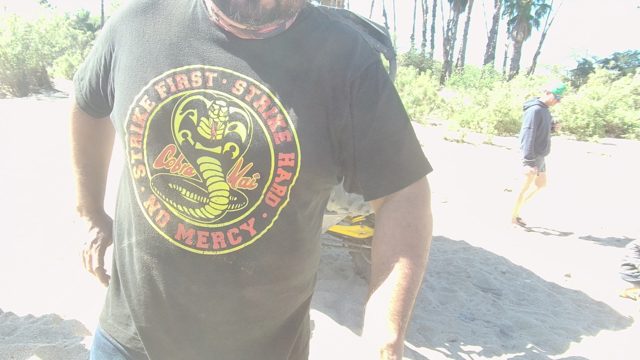 LOS CABOS BCS MEXICO-2022: Man in Cobra Kai T-Shirt on Sandy Ground