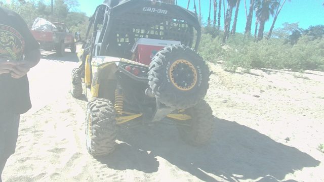 LOS CABOS BCS MEXICO-2022: Person with Red Disc near Off-road Vehicle on Sandy Ground