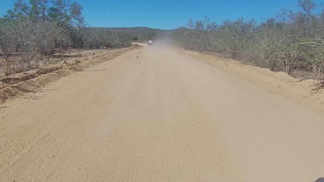 LOS CABOS BCS MEXICO-2022: Vehicle Creating Dust Cloud on Arid Dirt Road