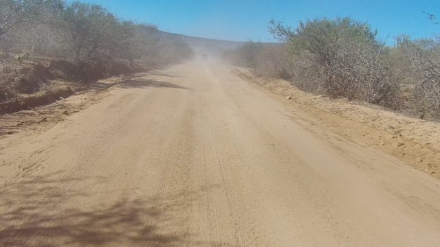 LOS CABOS BCS MEXICO-2022: Dusty Dirt Road with Vehicle Creating Dust Cloud
