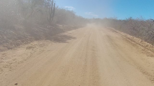 LOS CABOS BCS MEXICO-2022: Dusty Dirt Road with Vehicle Moving Away