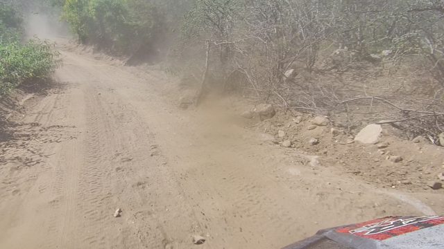 LOS CABOS BCS MEXICO-2022: Vehicle Traveling on Dusty Dirt Road Through Arid Bushes