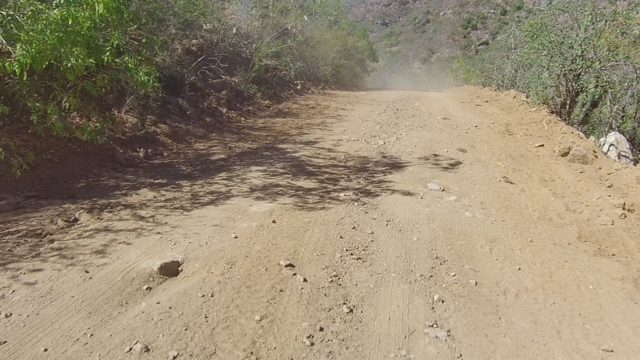 LOS CABOS BCS MEXICO-2022: Dusty Dirt Road Through Arid Mountain Landscape
