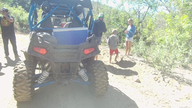 LOS CABOS BCS MEXICO-2022: Group near Blue Off-road Vehicle in Arid Terrain