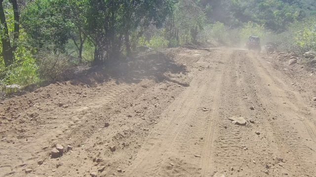 LOS CABOS BCS MEXICO-2022: Vehicle Traveling on Dusty Dirt Road Through Forested Terrain
