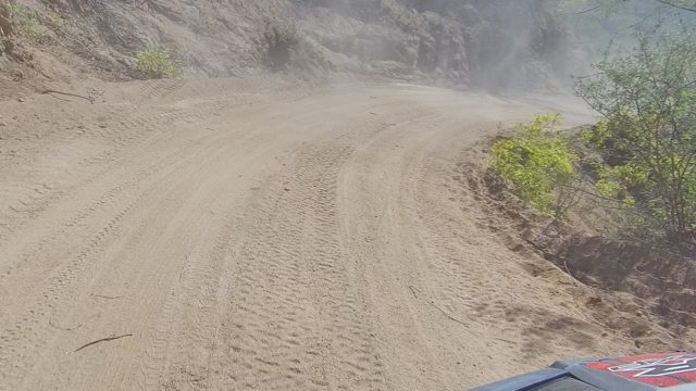 LOS CABOS BCS MEXICO-2022: Vehicle Driving on Dusty Dirt Road Through Rocky Terrain