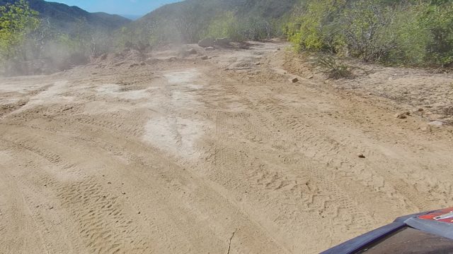 LOS CABOS BCS MEXICO-2022: Vehicle Driving on Dusty Dirt Road Through Hilly Terrain