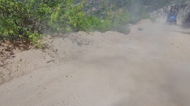 LOS CABOS BCS MEXICO-2022: Dusty Dirt Road with Truck Driving Through Hilly Terrain