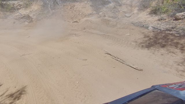 LOS CABOS BCS MEXICO-2022: Vehicle Driving on Dusty Dirt Road Through Arid Terrain