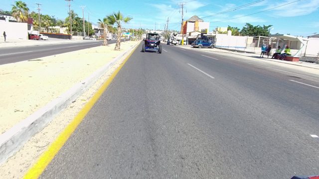 LOS CABOS BCS MEXICO-2022: Vehicle Traveling Along a Street with Passing Structures and Vehicles