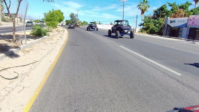 LOS CABOS BCS MEXICO-2022: Vehicles Traveling Along a Curving Road with Roadside Greenery